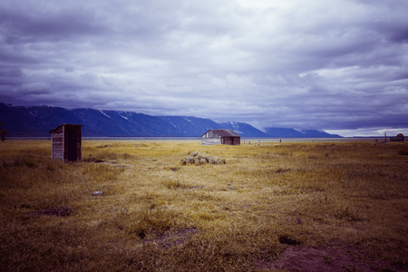 Old House, movement of cloud in Mountains at dusk time. Rural Landscapes. Old house on the field over mountains and blue skyの写真素材