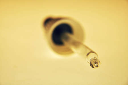 closeup detail of a pipette with light brown background