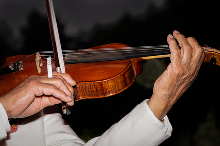 Somebody smoking and playing violin at nightの写真素材