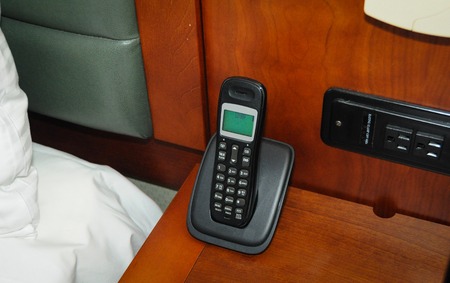 Wireless phone in the night table right near the bed.の写真素材