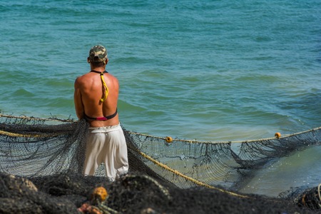 Man picking up the net after fishing