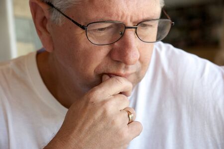 Pensive mature man closeup biting lip