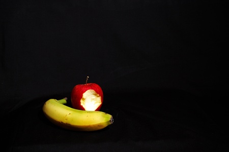 An apple and banana on a black backgroundの写真素材