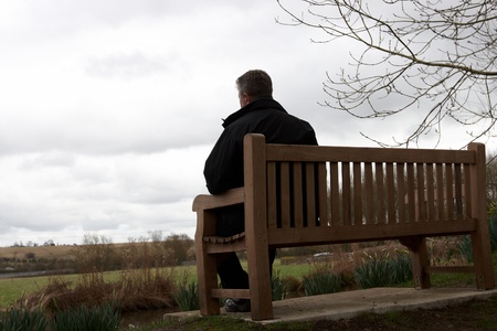 Mature Male sitting on a bench looking out over the Welsh countrysideの写真素材