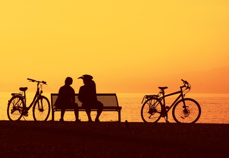 Two cyclist sitting relaxing by the beachの写真素材