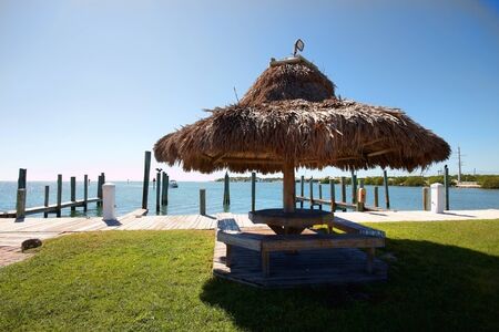 A picnic table and grass sun shade by the waterの写真素材