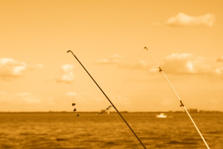 Two fishing rods with gut line in orange skyの写真素材