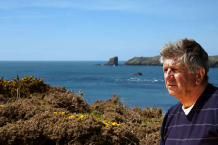 Mature man outdoor portrait with the sea in the backgroundの写真素材