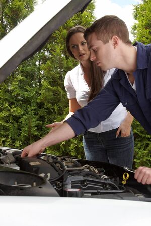 A car mechanic at work with a concerned customer