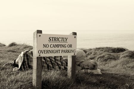 A mature man asleep on a grass bankの写真素材