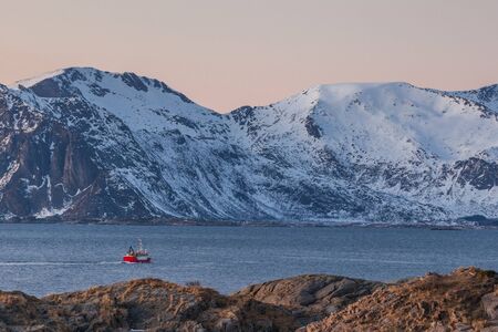 fishing boat with dramatic sunset in background in lofoten, Norway. Amazing landscape.の写真素材