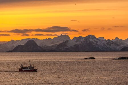 fishing boat with dramatic sunset in background in lofoten, Norway. Amazing landscape.の写真素材