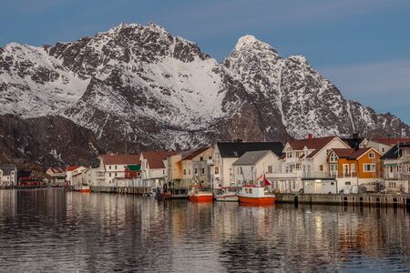 Beautiful winter landscape of picturesque harbor with fishing boat and traditional Norwegian rorbus in Lofoten islands, Norwayの写真素材