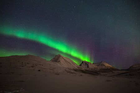 northern lights, Polar lights with many clouds and stars on the sky over fjord mountains in the North of Europe , Tromso, Norway, long shutter speed.の写真素材