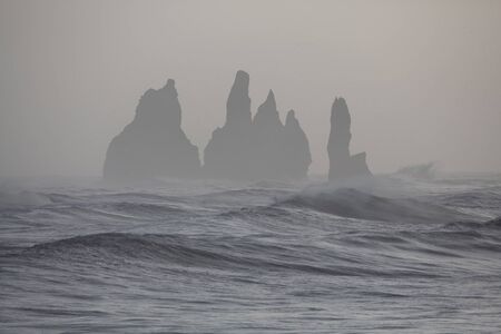 Storm on Atlantic ocean. Breathtaking morning view of Reynisdrangar cliffs with many gulls in the...
