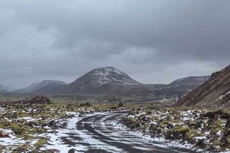 A road passing through a lava field. Typical icelandic landscape in early spring and winter. Northern Europe. Iceland.の写真素材