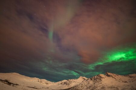 northern lights, Polar lights with many clouds and stars on the sky over mountains in the North of...
