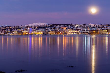 sunrise with amazing magenta color and moon over Tromso, Norway. Winter. Polar night. long shutter speedの写真素材