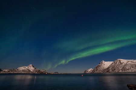Polar lights, Aurora borealis over fjord, mountains with many stars on the sky in Lofoten islands, Norway, long shutter speed.の写真素材