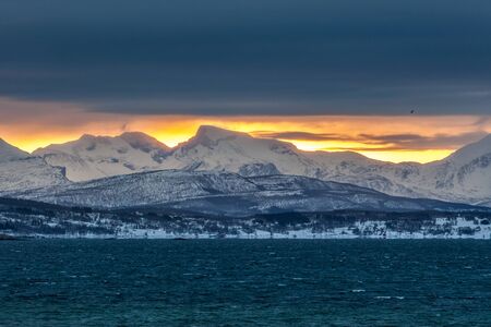 Dramatic cloudy sunset under blue hour over fjord on Lofoten islands, Norway. long exposure