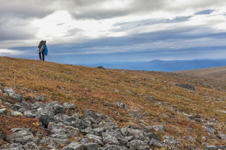 Man Traveler with backpack hiking Travel Lifestyle concept beautiful mountains landscape on background Autumn vacations activity outdoorの写真素材