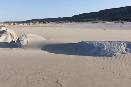 stones sticking out of sand. Sand Texture. Brown sand.