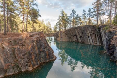 Old abandoned silver mine with blue, emerald water on a sunny evening. silverberg in central Sweden. selective focusの写真素材