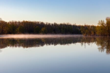 fogs over the river. Spring morning landscape. forest in the background