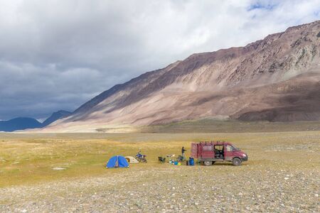 Tourists camping in Mongolian hills. Tents under the open cloudy sky.