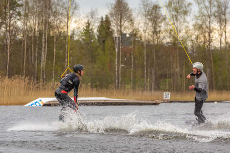Fagersta, Sweden - Maj 07, 2020: Two teenagers , a girl and a boy, wakeboarders on a lake during a physical education lesson.のeditorial素材