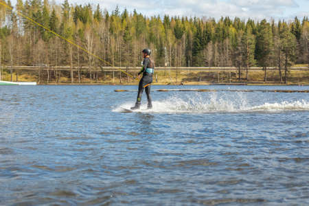 Fagersta, Sweden - Maj 01, 2020: Wakeboarder surfing across a lake.のeditorial素材