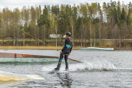 Fagersta, Sweden - Maj 01, 2020: Wakeboarder surfing across a lake.のeditorial素材