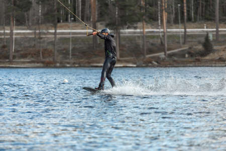 Fagersta, Sweden - Maj 01, 2020: Wakeboarder surfing across a lake.のeditorial素材