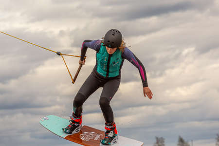 Fagersta, Sweden - Maj 07, 2020: Teen boy make an extreme jump on wakeboarding, around there are a lot of splashes. Upside down on a wakeboardのeditorial素材