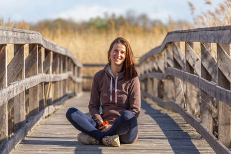 girl siting on a wooden walk way .の写真素材
