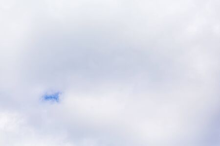 continuous clouds with a small hole through which the blue sky shines through.の写真素材