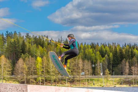 Fagersta, Sweden - Maj 26, 2020: Wakeboarder flies in the air on wakeboard. Wakeboarding is Extreme Sportsのeditorial素材