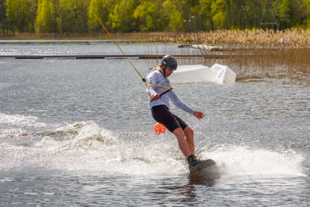 Fagersta, Sweden - Maj 18, 2020: Teenager boy wakeboarders on a lake during a physical education lessonのeditorial素材