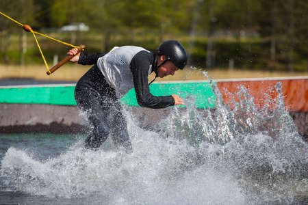 Fagersta, Sweden - Maj 26, 2020: Teen Wakeboarder on wakeboard landed in water surrounded by spray. Wakeboarding is an extreme sport.のeditorial素材