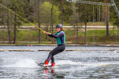 Fagersta, Sweden - Maj 26, 2020: Young wakeboarder rides a wakeboard on the lake. Wakeboarding is cool, extreme sportのeditorial素材