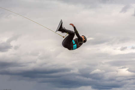 Fagersta, Sweden - Maj 07, 2020: Teen boy make an extreme jump on wakeboarding, around there are a lot of splashes. Upside down on a wakeboardのeditorial素材