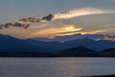 Beautiful blue ridge mountain sunset with orange sky. Mountain Lake in Mongolian Altai.の写真素材