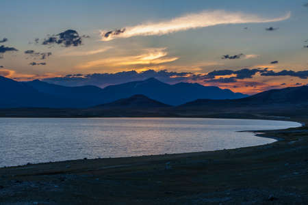 Beautiful blue ridge mountain sunset with orange sky. Mountain Lake in Mongolian Altai.の写真素材