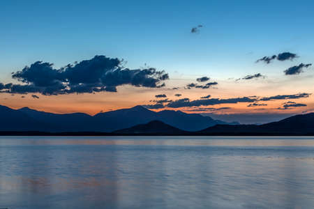 Beautiful blue ridge mountain sunset with orange sky. Mountain Lake in Mongolian Altai.の写真素材