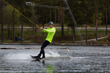 Fagersta, Sweden - Maj 26, 2020: Young wakeboarder rides a wakeboard on the lake. Wakeboarding is cool, extreme sportのeditorial素材