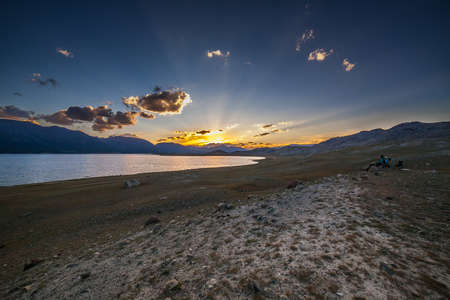 Beautiful blue ridge mountain sunset with orange sky. Mountain Lake in Mongolian Altai.の写真素材