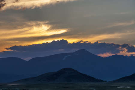 Beautiful blue ridge mountain sunset with orange sky in Mongolian Altai.の写真素材