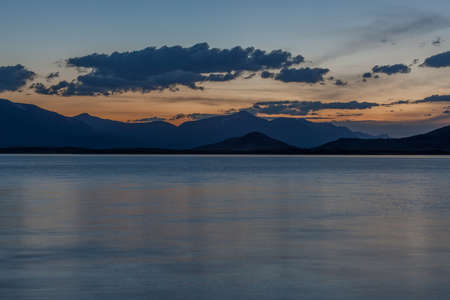 Beautiful blue ridge mountain sunset with orange sky. Mountain Lake in Mongolian Altai.の写真素材
