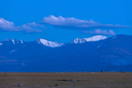 Beautiful blue ridge mountain sunset with orange sky in Mongolian Altai.の写真素材
