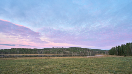 Purple Sunset over a field and hillの写真素材